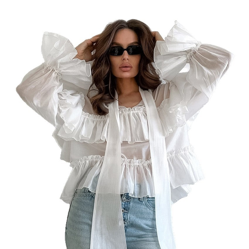 vrouw poseert met witte blouse en een jeans met een zonnebril op